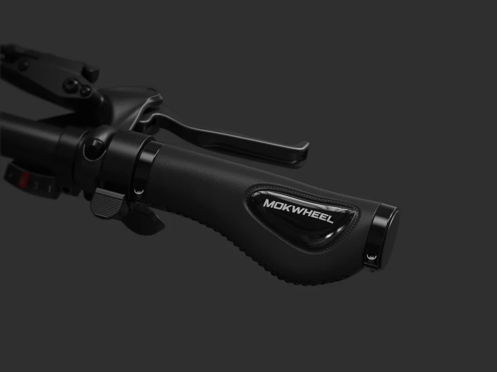 Close-up of a black bicycle handlebar with hand grip labeled "Mokwheel" and a brake lever against a plain dark background.