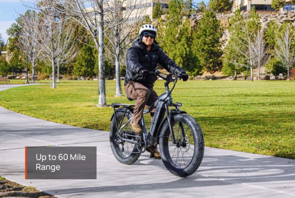 A person in a helmet and jacket rides the Tor Plus Ebike along a park path; a caption reads "Up to 60 Mile Range.