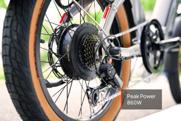 Close-up of the Slate Ebike’s rear wheel, displaying the motor, gears, derailleur, and tire. A label shows “Peak Power 860W.”.