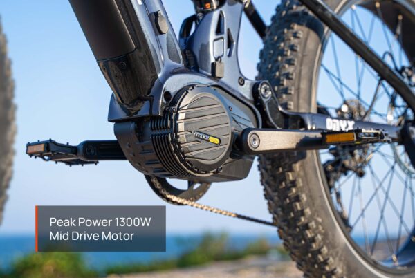 Close-up of the Onyx Ebike’s 1300W mid-drive motor, with pedals, chain, and rear wheel visible against an outdoor background.