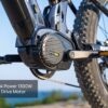 Close-up of a black mid drive motor labeled "Peak Power 1300W" mounted on the Onyx ST Ebike, with a blurred outdoor background.