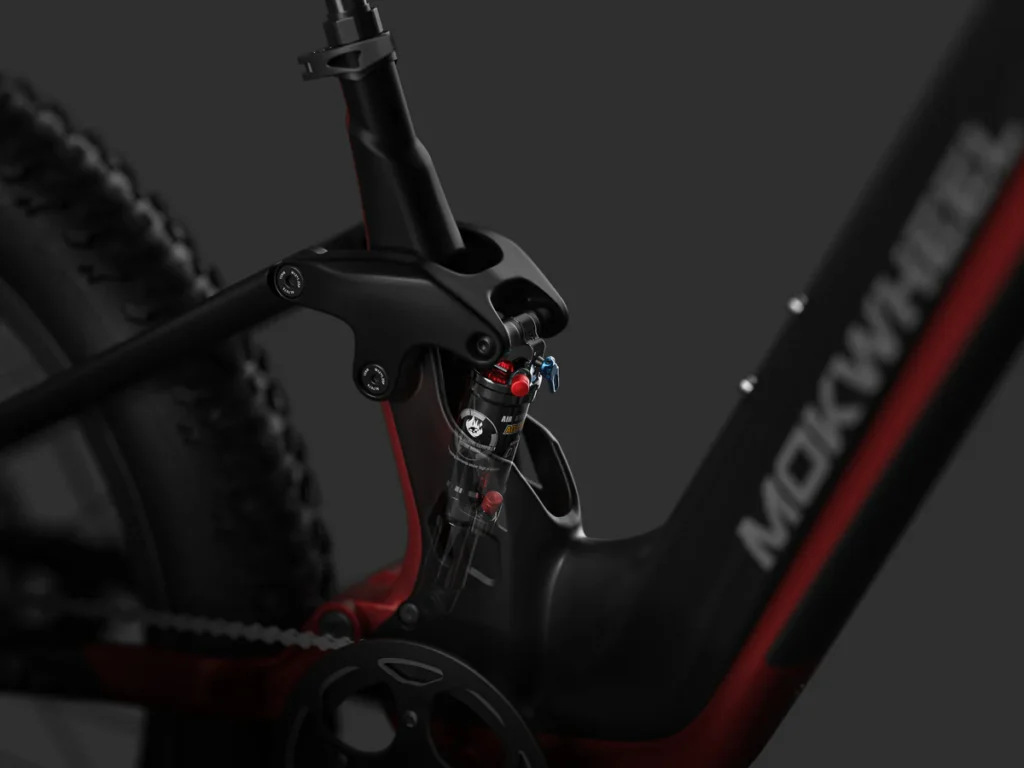 Close-up of a MOKWHEEL electric bicycle frame, highlighting the rear suspension system and part of the tire.