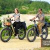 Two people ride Basalt ST 2.0 Ebikes on a dirt path near the beach, with text overlay stating "Up to 80 Mile Range.
