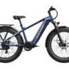 The Basalt Ebike, a blue electric fat tire bicycle with front suspension, disc brakes, and a rear cargo rack, is displayed in side profile against a white background.