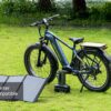 A Basalt Ebike is parked on grass beside a portable solar panel and battery pack. Text overlay: “Inverter Compatible.”.