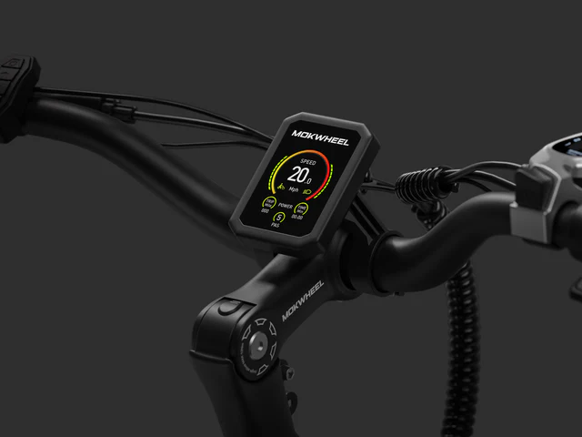 Close-up of an e-bike handlebar featuring a digital display showing speed, power, and other ride metrics against a dark background.