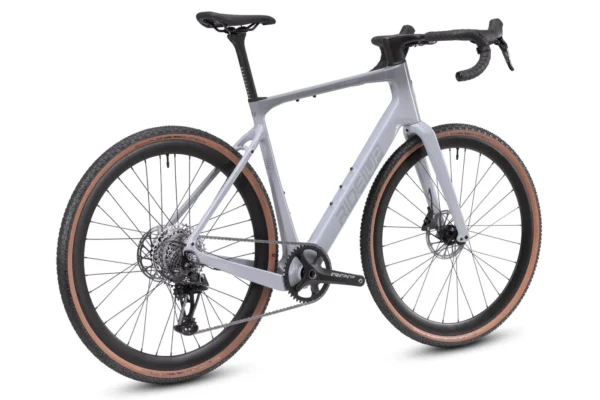 The CF Racer1 is a modern gravel bike featuring a light gray frame, drop handlebars, disc brakes, and tan-walled tires, displayed from a rear-side angle on a white background.