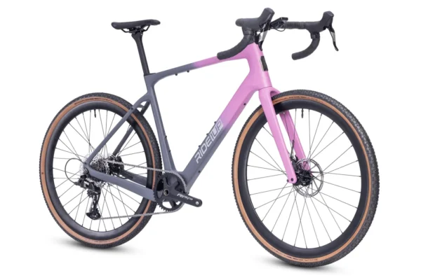 The CF Racer1 gravel bike in gray and pink features drop handlebars, disc brakes, and tan-walled tires, displayed from a side angle on a white background.