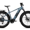 Aventon Aventure electric mountain bike in blue with fat tires, a rear rack, and a front suspension fork.