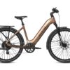 Aventon step-through electric commuter bike in copper, featuring a rear rack, fenders, and disc brakes.