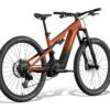 An Aventon full-suspension electric mountain bike in an orange-to-black fade paint job.